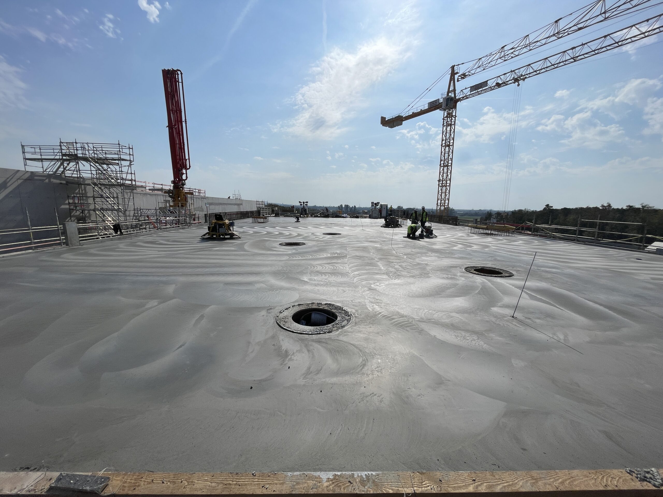 Bearbeitung einer großen Betonfläche mit Glättmaschinen
