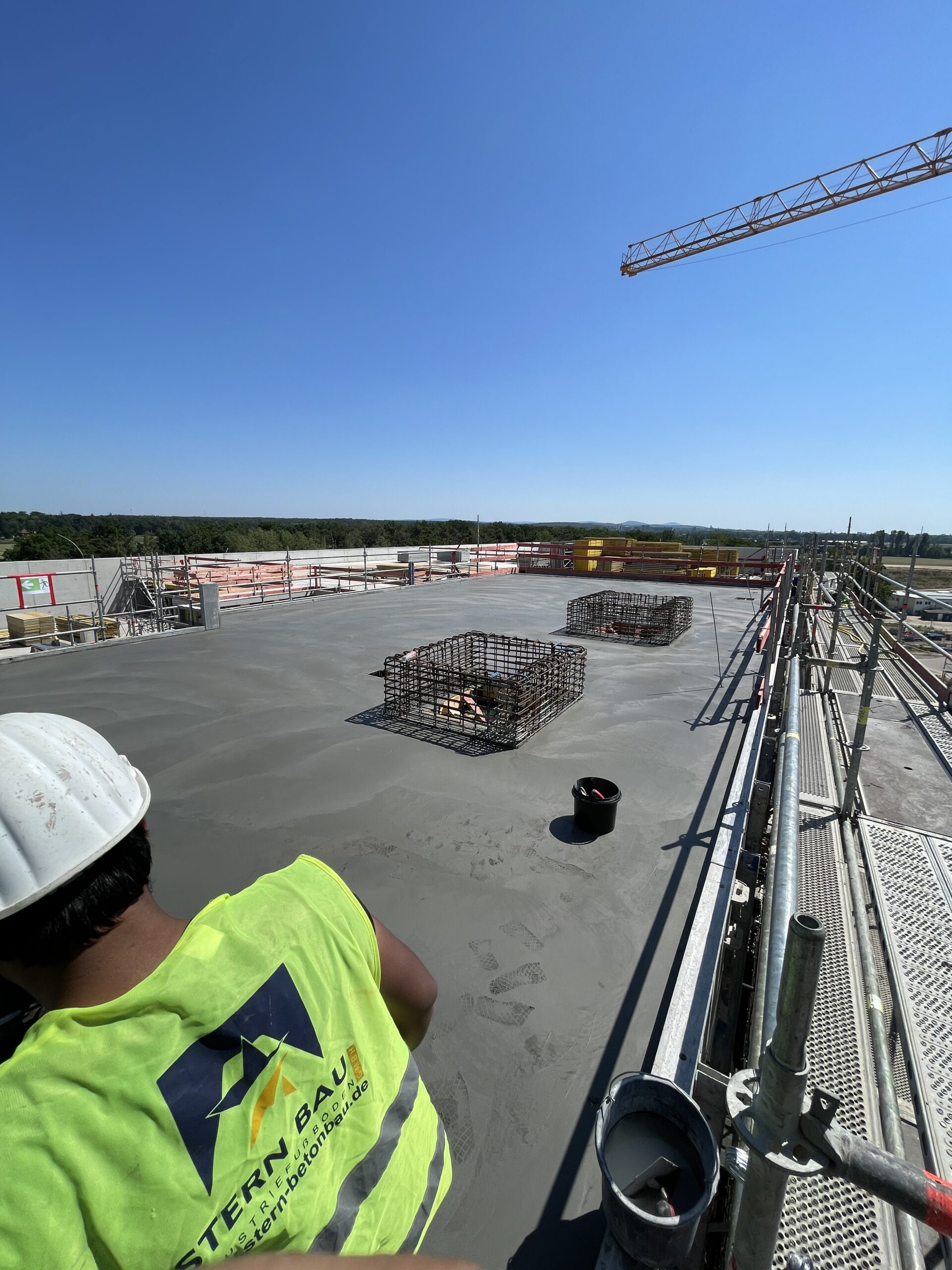 Stern Bau Mitarbeiter mit Warnweste auf einer Industrieboden-Baustelle