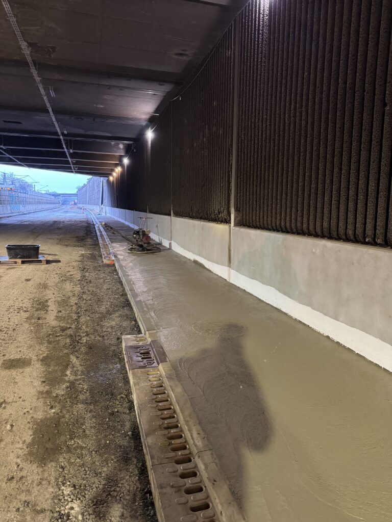 Maschinelle Bearbeitung einer langen Betonfläche durch Stern Bau